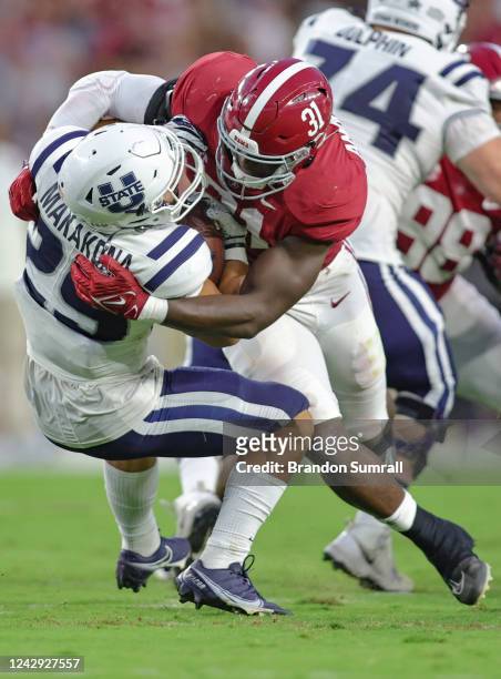 Will Anderson Jr. #31 of the Alabama Crimson Tide meets Pailate Makakona of the Utah State Aggies in the backfield during the first half at Bryant...