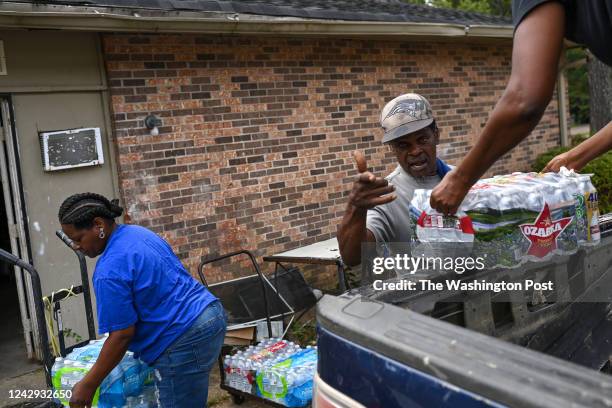 Rodney Moore , maintenance supervisor at Addison Place apartments receives cases of bottle water from City of Jackson worker Dianna Davis and Andrea...