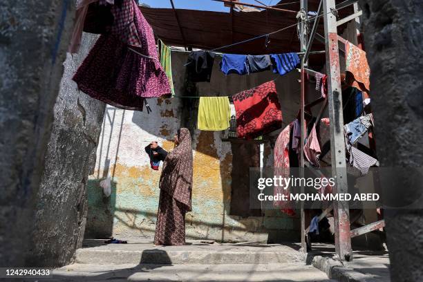 Woman hangs freshly-washed clothes to dry in her home in the Jabalia camp for Palestinian refugees in the north of the Gaza Strip on September 4,...