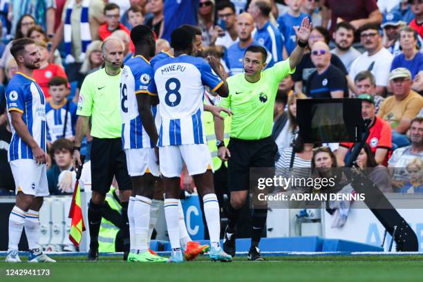 English referee Tony Harrington speaks with Brighton's players as he disallows their third goal scored by Brighton's Argentinian midfielder Alexis...