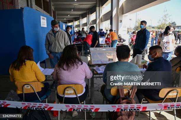 People wait in line to cast their vote during a referendum to approve or reject a new Constitution at a polling station in Santiago, on September 4,...