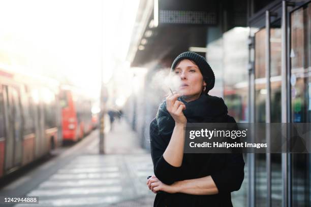 front view portrait of woman on train station, smoking cigarette. - beautiful women smoking cigarettes 個照片及圖片檔