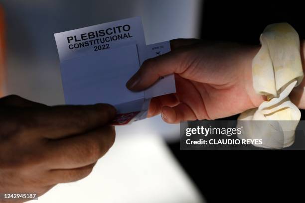 Woman casts her vote during a referendum to approve or reject a new Constitution at a polling station in Santiago, on September 4, 2022. - More than...