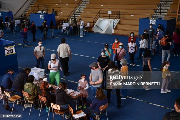 People wait in line to cast their vote during a referendum to approve or reject a new Constitution at a polling station in Santiago, on September 4,...