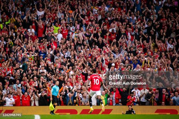 Manchester United fans celebrate after Marcus Rashford of Manchester United scored a goal to make it 2-1 during the Premier League match between...