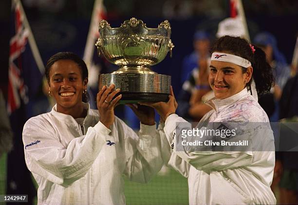 Arantxa Sanchez Vicario of Spain and Chanda Rubin of the USA pose with the trophy after defeating Mary Joe Fernandez and Lindsay Davenport of the USA...