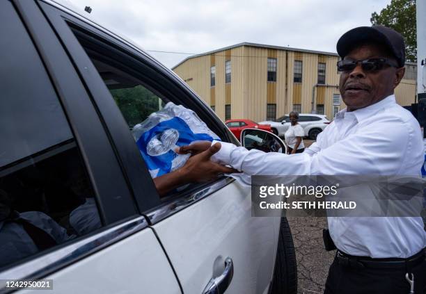 Member of Progressive Morningstar Baptist Church hands out cases of water after a Sunday morning service in Jackson, Mississippi, on September 4,...
