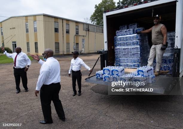 Members of Progressive Morningstar Baptist Church direct people to get bottled water following a Sunday morning service in Jackson, Mississippi, on...