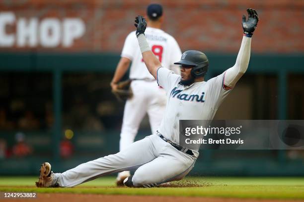 Jerar Encarnacion of the Miami Marlins slides safely into second after a single and a fielding error by Eddie Rosarioof the Atlanta Braves in the...