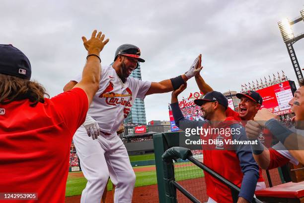 Albert Pujols of the St. Louis Cardinals is congratulated after hitting he go-ahead, two-run home run, his 695th career home run, against the Chicago...