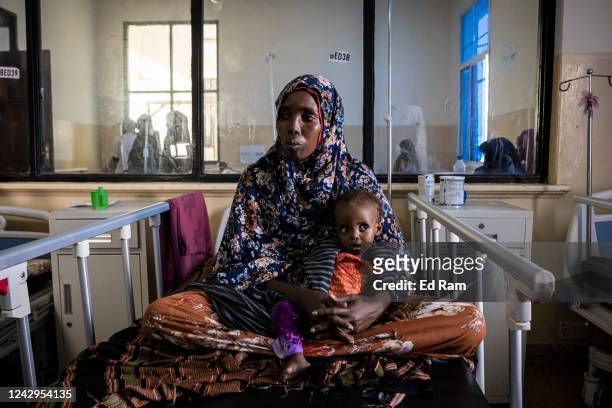 Baby lies with its mother while being treated for severe acute malnutrition as Martin Griffiths, Under Secretary General for the United Nations...