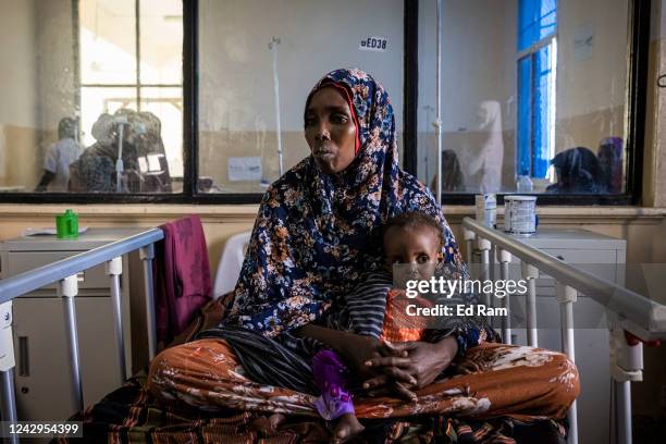 Baby lies with its mother while being treated for severe acute malnutrition as Martin Griffiths, Under Secretary General for the United Nations...