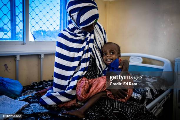 Baby lies with its mother while being treated for severe acute malnutrition as Martin Griffiths, Under Secretary General for the United Nations...