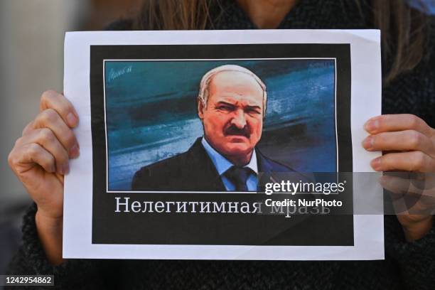 Protester holds a poster with an image of President of Belarus, Alexander Lukashenko, and words 'Illegitimate scum'. Members of the local Belarusian...