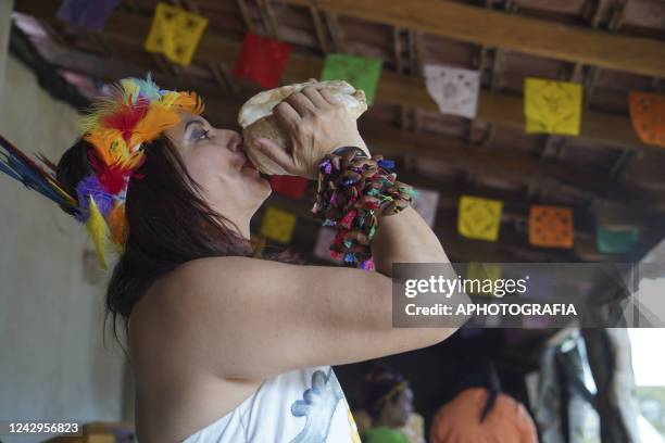 An Indigenous woman plays a conch during a ceremony on International Indigenous Women's Day on September 4, 2022 in Sonsonate, El Salvador....