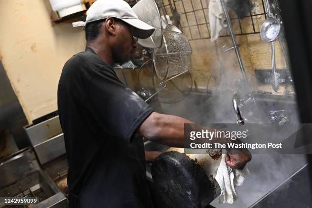 Johnny Ts Bistro & Blues dishwasher Anthony Caviness pours boiled water into a sink to wash dishes on September 4, 2022 in Jackson, Mississippi. The...