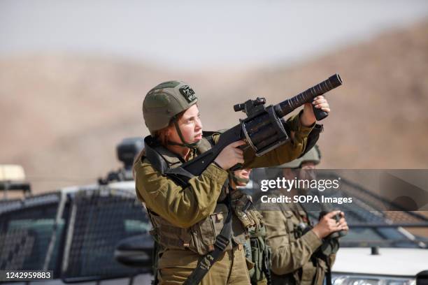 An Israeli soldier fires tear gas canisters at the Palestinian youths as they search for gunmen who opened fire on an Israeli bus, wounding 7...