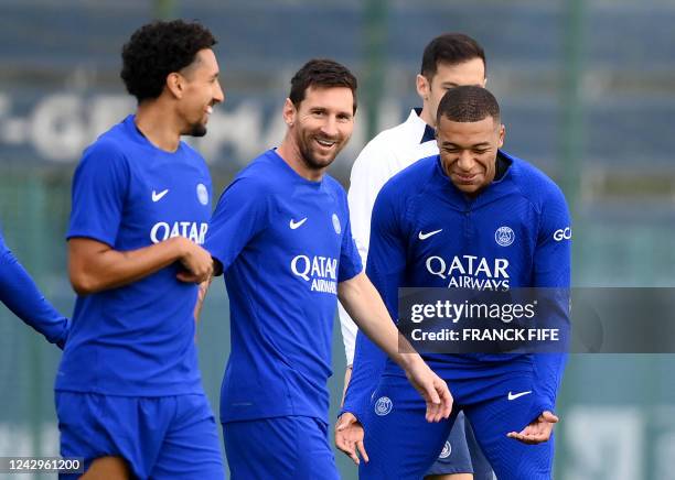 Paris Saint-Germain's Brazilian defender Marquinhos shares a laugh with Paris Saint-Germain's Argentinian forward Lionel Messi and Paris...