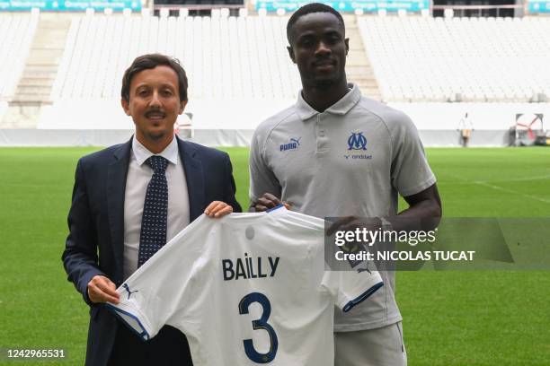 Marseille's Ivorian defender Eric Bailly poses with Marseille's Spanish president Pablo Longoria with Olympique de Marseille's jersey after his...