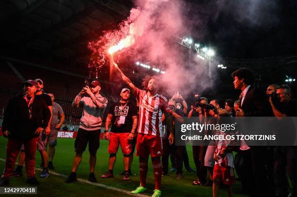 Olympiakos' new Brazilian player Marcelo holds a flare during his official presentation at the Georgios Karaiskakis stadium in Athens on September 5,...