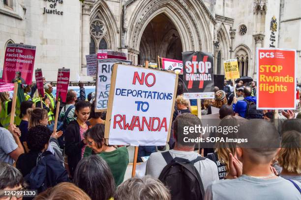 Protester holds a placard which states "No deportations to Rwanda" during the demonstration. Pro-refugee protesters gathered outside the Royal Courts...