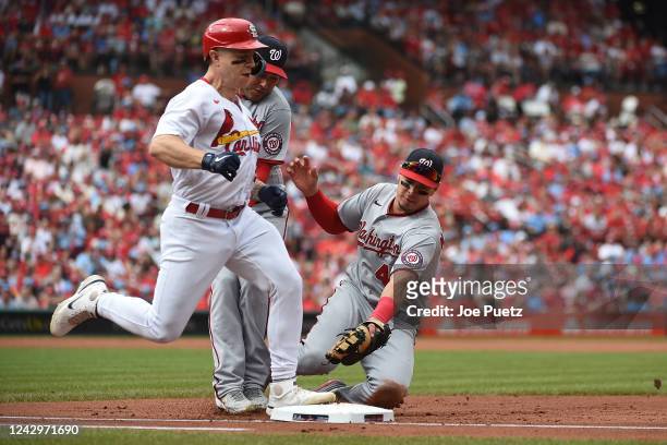 Tyler O'Neill of the St. Louis Cardinals beats Joey Meneses of the Washington Nationals to first base for an infield hit in the first inning at Busch...