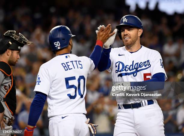 Freddie Freeman of the Los Angeles Dodgers is congratulated by Mookie Betts after hitting a two run home run against starting pitcher Logan Webb of...