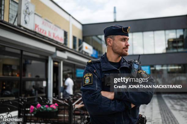 Police officer Michael Cojocaru patrols the main square in Rinkeby, Sweden, on August 31, 2022. - Gang shootings have escalated and spread across...