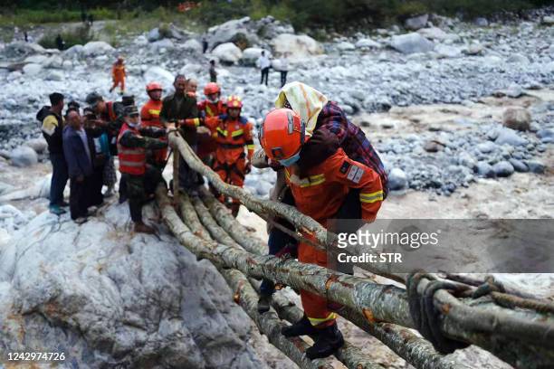 This photo taken on September 5, 2022 shows rescue workers evacuating residents after a 6.6-magnitude earthquake in Luding county, Ganzi, in China's...