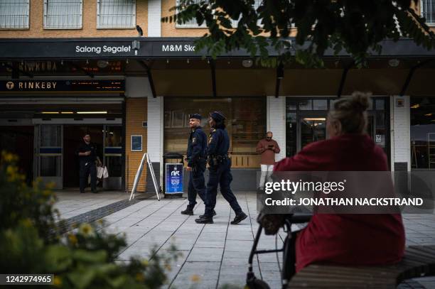 Police officers Michael Cojocaru and Rissa Seidou patrol the main square in Rinkeby, Sweden, on August 31, 2022. - Gang shootings have escalated and...