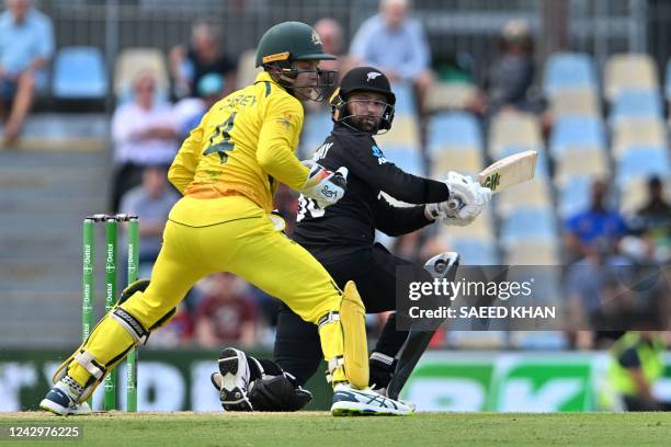 New Zealand's Devon Conway plays a shot as Australia's wicketkeeper Alex Carey tries to field during the first one-day international cricket match...