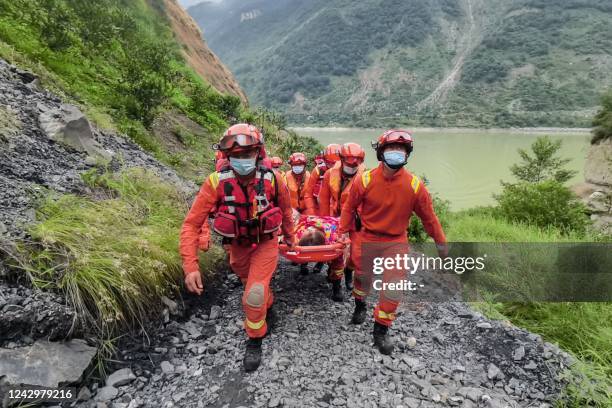 Rescue workers carry an injured person after a 6.6-magnitude earthquake in Luding county, Ganzi Prefecture in China's southwestern Sichuan province...