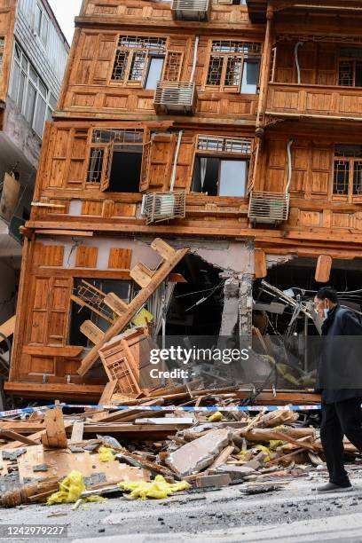 Man walks past a damaged building after a 6.6-magnitude earthquake in Luding county, Ganzi Prefecture in China's southwestern Sichuan province on...