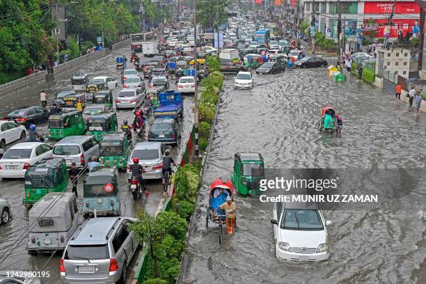 Vehicles wade through a waterlogged street following heavy monsoon rains in Dhaka on September 6, 2022.