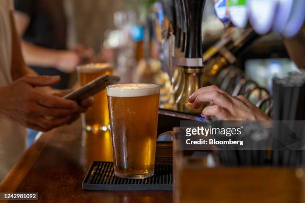 Customer prepares to use a mobile phone at a contactless payment terminal in the East Dulwich Tavern pub in south London, UK, on Saturday, Sept. 3,...