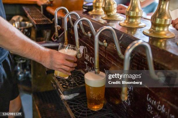 Bartender pours a draught beer from a tap in the East Dulwich Tavern pub in south London, UK, on Saturday, Sept. 3, 2022. The government has been...