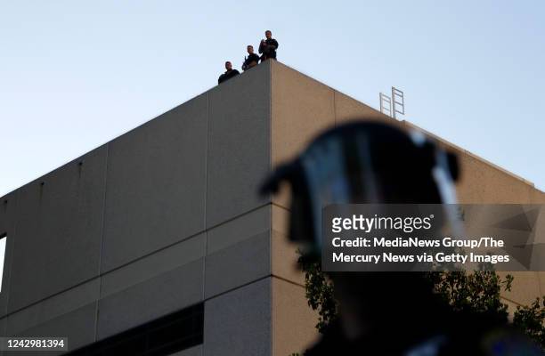 Police officers keep an eye on a protest for the killing of George Floyd in downtown Redwood City, Calif., on Tuesday, June 2, 2020.