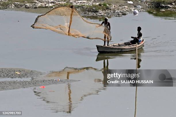 Fisherman casts a net in the waters of river Yamuna in New Delhi on September 6, 2022.