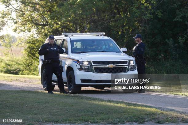 Royal Canadian Mounted Police officers stand next to a police vehicle outside the house where one of the stabbing victims was found in Weldon,...