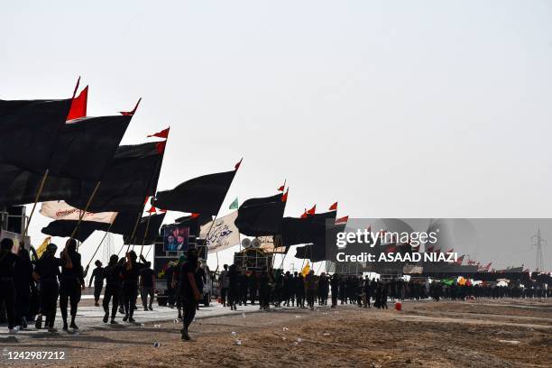 Shiite Muslim pilgrims march with flags en route to Karbala from Iraq's southern province of al-Muthanna on September 6 ahead of the holiday of...