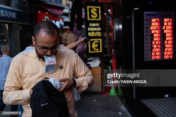 Customer holds Turkish lira banknotes outside a currency changer on a street in Istanbul on September 6 as Turkey's economy is suffering its biggest...