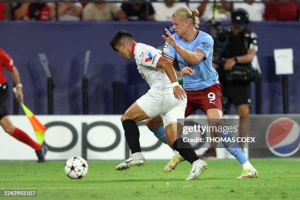 Sevilla's Argentinian defender Marcos Acuna fights for the ball with Manchester City's Norwegian striker Erling Haaland during the UEFA Champions...