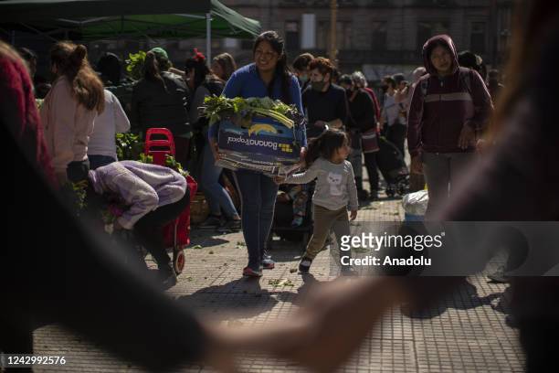 People looks for vegetables that farm workers give away as a protest against hunger in Buenos Aires, Argentina, Sept. 6, 2022. Hundreds of farm...