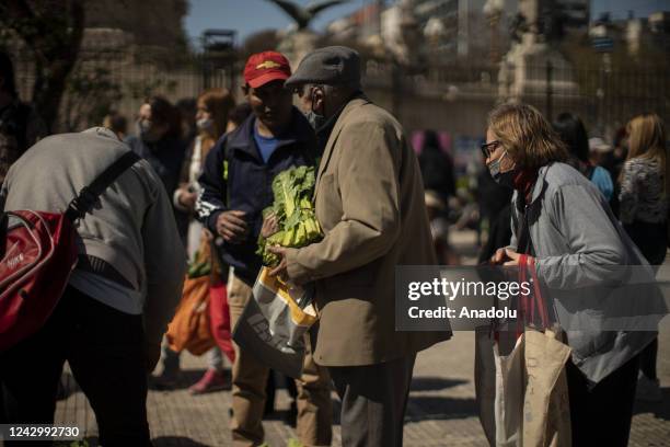 People looks for vegetables that farm workers give away as a protest against hunger in Buenos Aires, Argentina, Sept. 6, 2022. Hundreds of farm...