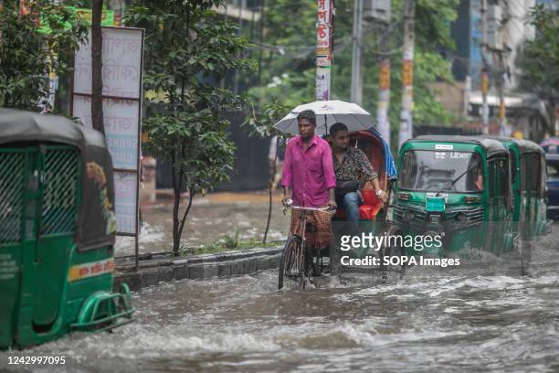 Tuk-tuks and Rickshaws try driving with passengers through the flooded streets of Dhaka after heavy rainfall. Heavy monsoon rains caused flooding on...