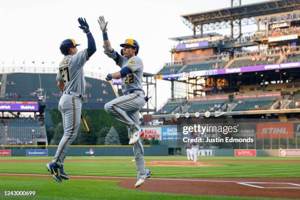 Christian Yelich of the Milwaukee Brewers celebrates his 499ft solo home run with Willy Adames in the first inning against the Colorado Rockies at...