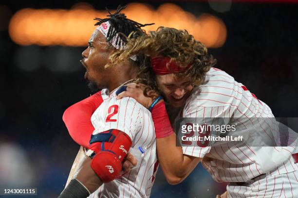 Jean Segura of the Philadelphia Phillies celebrates with Alec Bohm after hitting the game-winning RBI single in the bottom of the ninth inning...