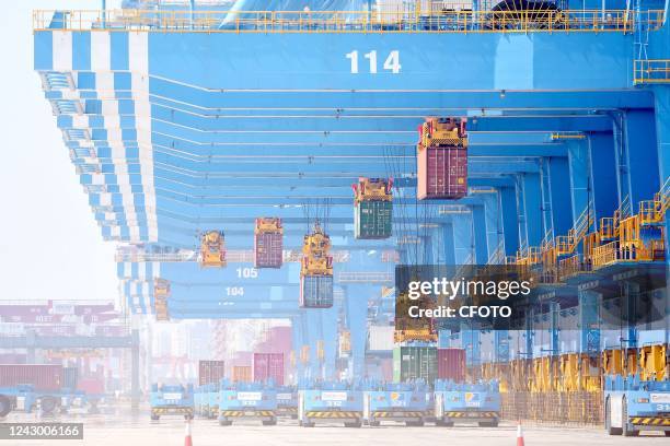 An unmanned bridge is hoisted to load and unload foreign trade containers at the fully automated wharf of Qingdao Port in Qingdao, Shandong province,...