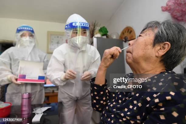 Staff member instructs elderly people on antigen testing at their home in Guiyang, Guizhou province, China, Sept 7, 2022.