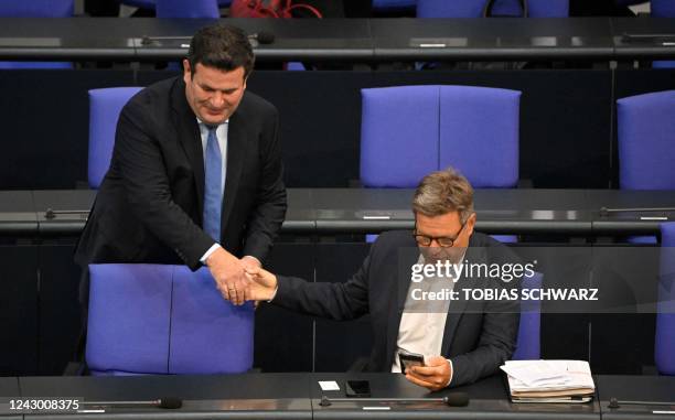 German Minister of Labour and Social Affairs Hubertus Heil and German Minister of Economics and Climate Protection Robert Habeck shake hands as they...